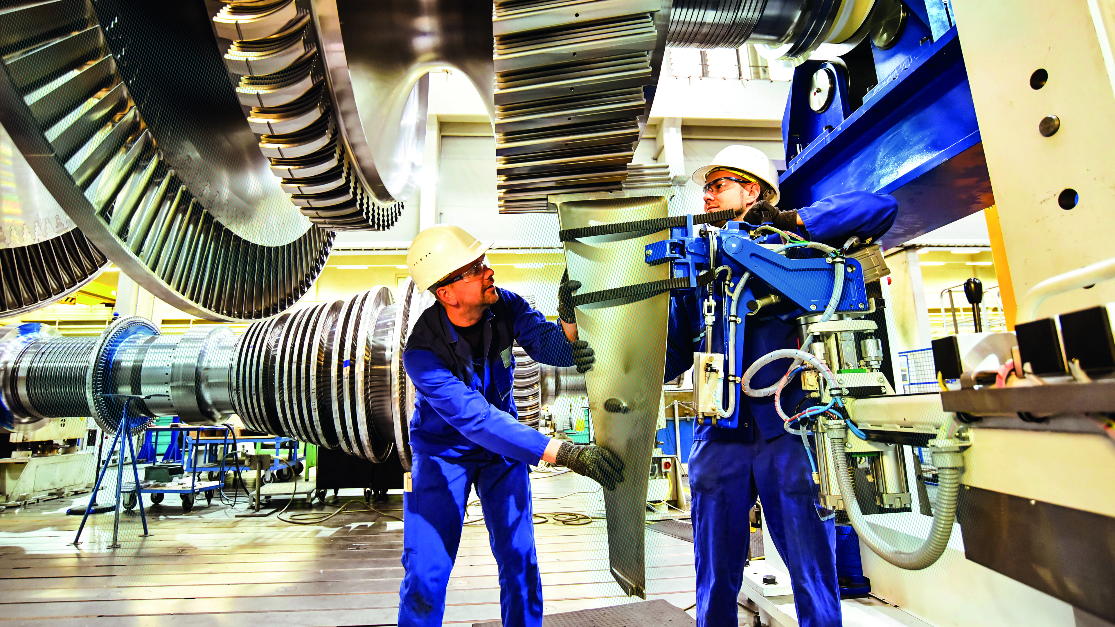 Two workers in assembly mount rotor blades