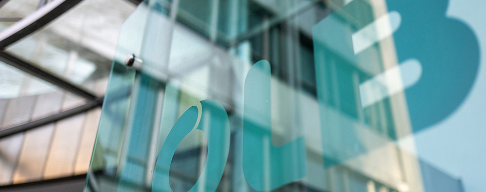 OLB-Logo auf Glasfassade eines modernen Bankgebäudes als Symbol für Echtzeit-Betrugsprävention und Compliance