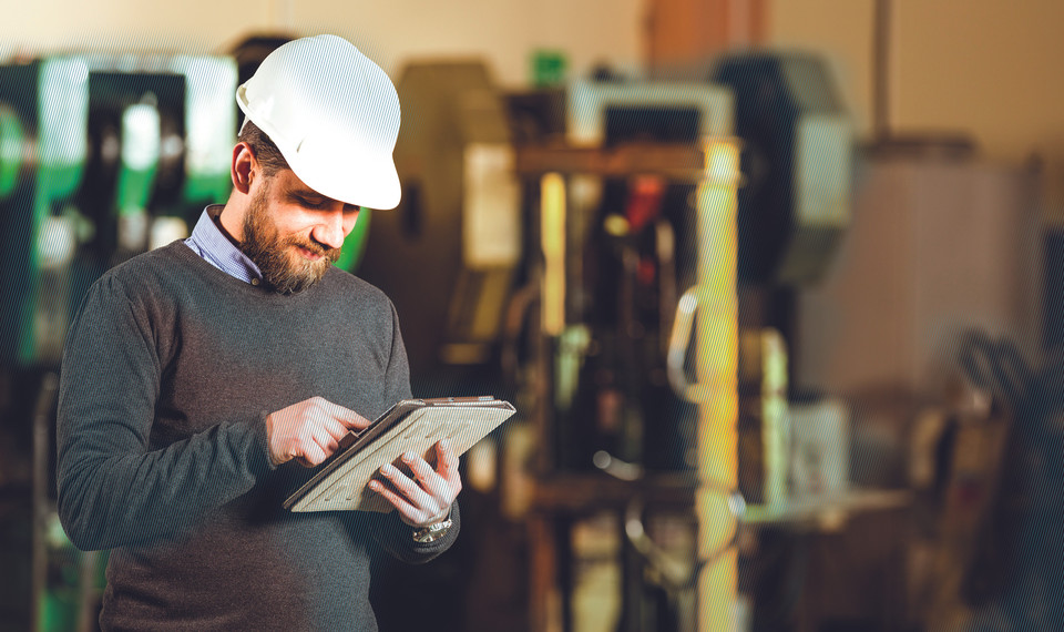 Man in production hall at tablet