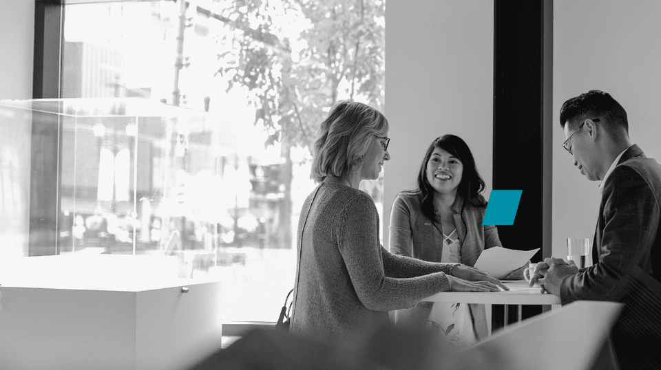 Two persons sitting at desk over print outs with data