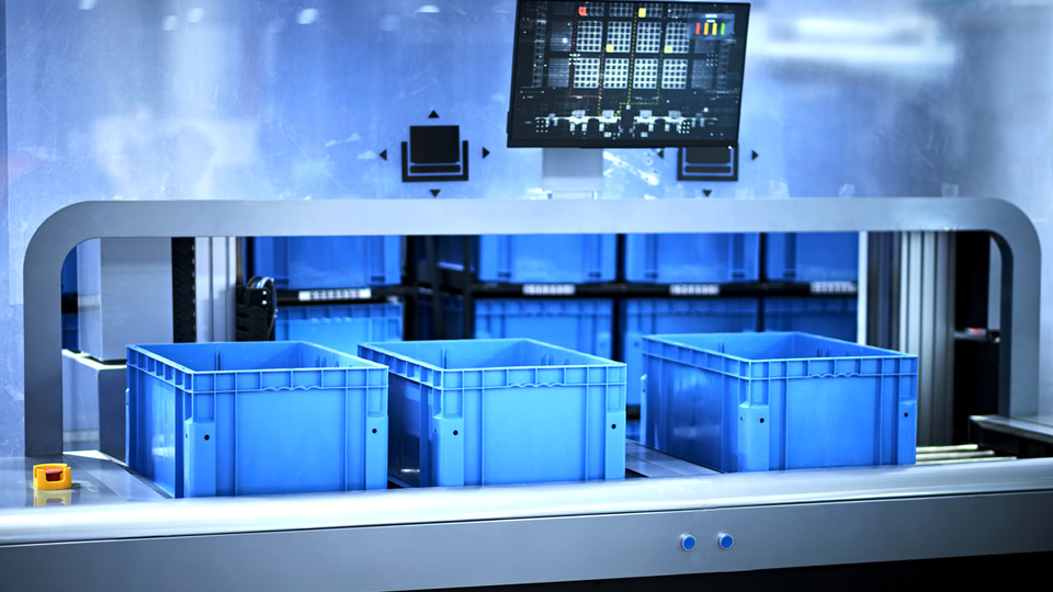Automatisierte industrielle Einrichtung mit blauen Kunststoff-Lagerbehältern in einer modernen Lagerumgebung.
