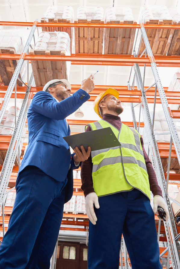Zwei Disponenten stehen in einem Lager und hält ein Tablet mit Software zur Bestandsoptimierung.