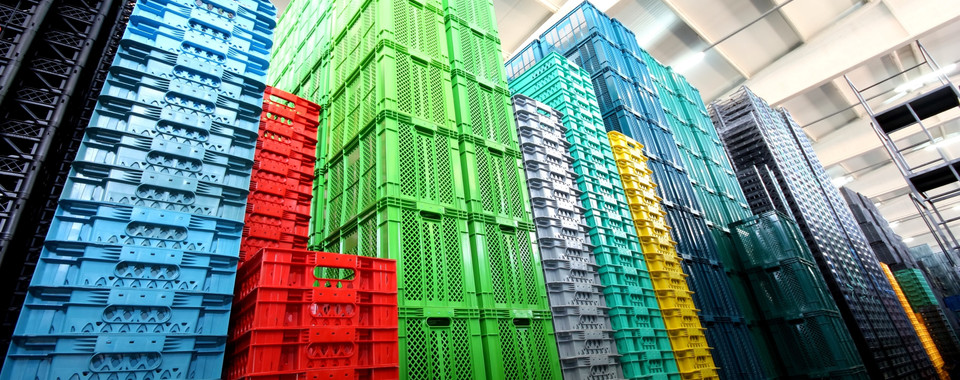 Colorful stacked storage crates in a warehouse, showcasing organization and efficiency in inventory management.