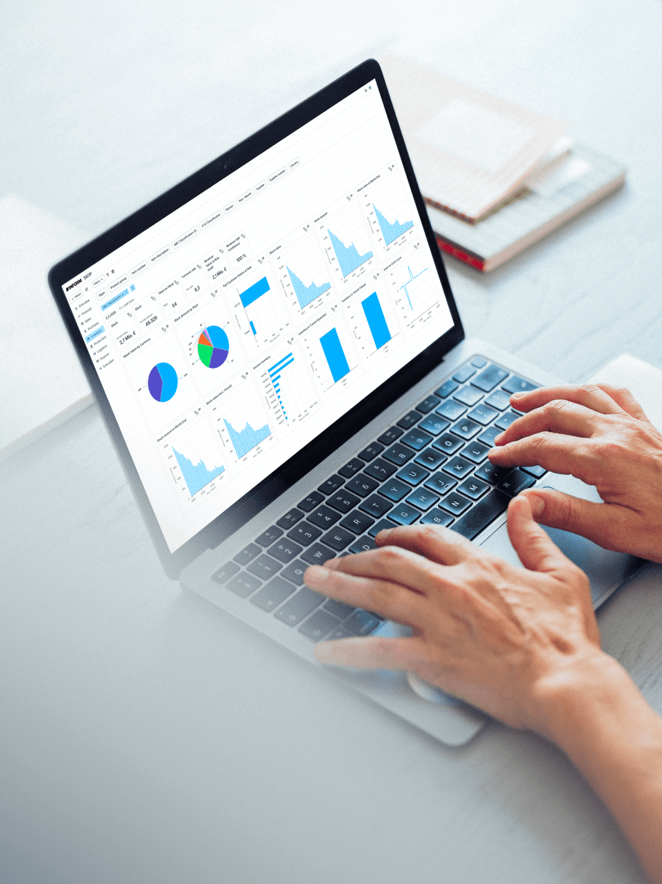 Person analyzing KPIs on a laptop, featuring colorful charts and graphs on a modern workspace table.