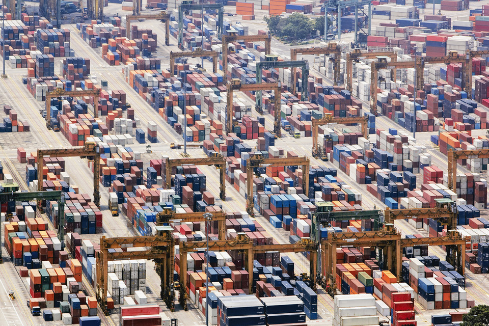 Aerial view of a busy shipping container terminal filled with vibrant containers and cranes for unloading cargo.