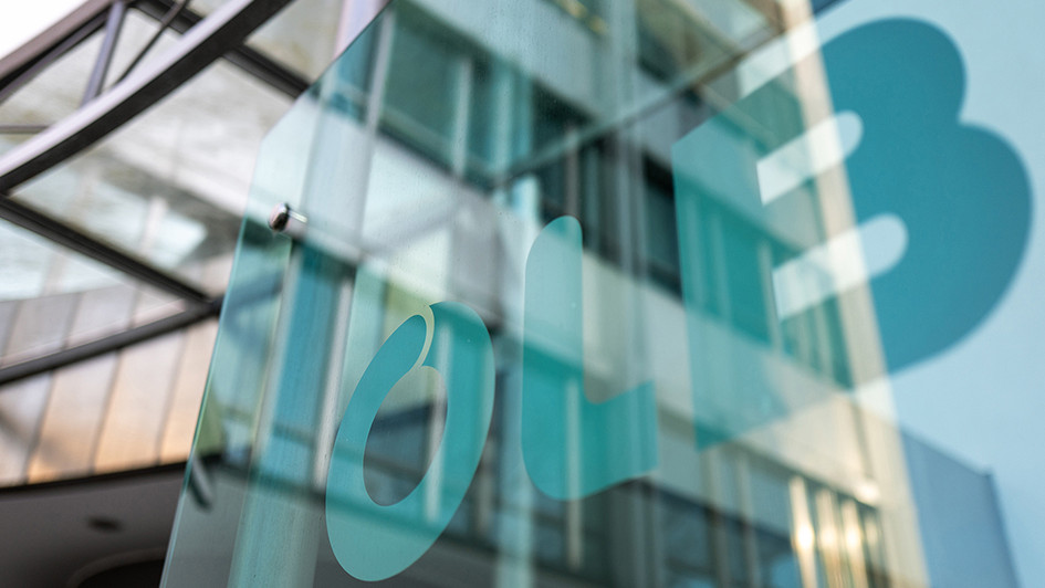 OLB logo on glass facade of a modern bank building, representing RiskShield-based real-time fraud prevention and banking compliance