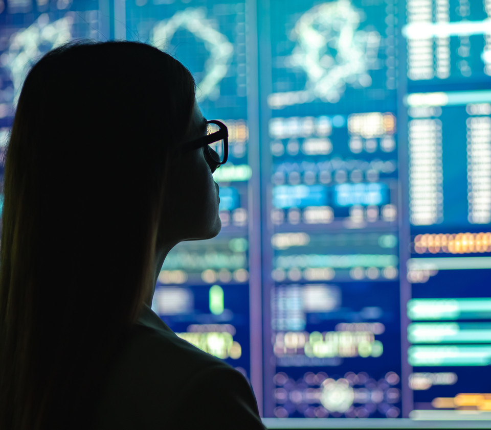 Woman looking at screens full of data