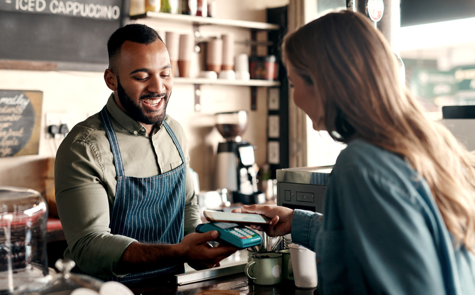 Woman at a food truck paying by card