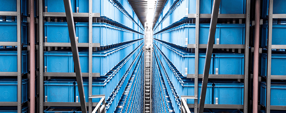 Efficient storage system featuring rows of blue containers in a modern warehouse environment.