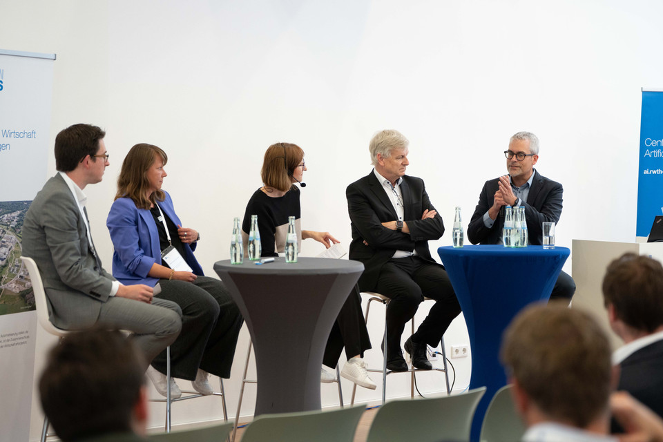 Vertreter aus Industrie und Forschung in einer lebhaften Podiumsdiskussion über Erfolgsfaktoren der KI-Einführung