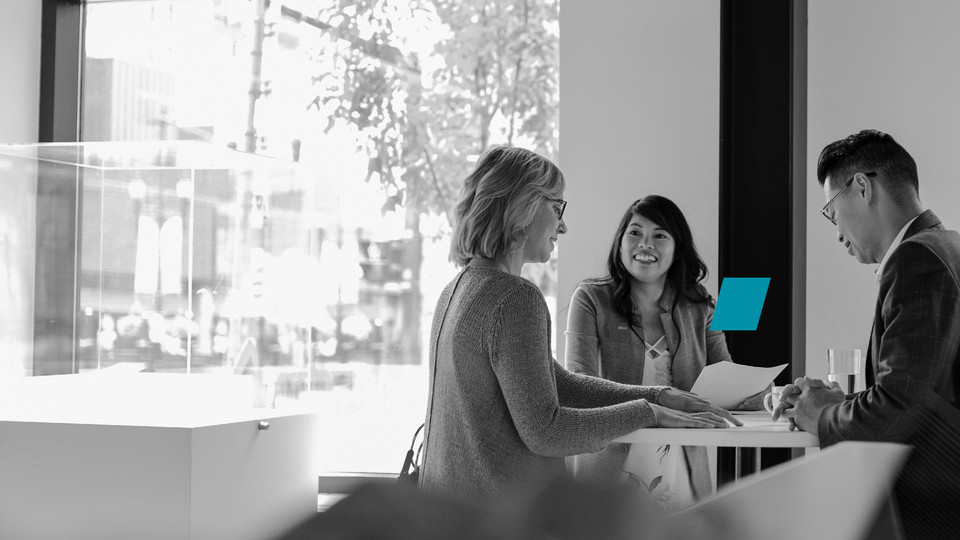 Two persons sitting at desk over print outs with data