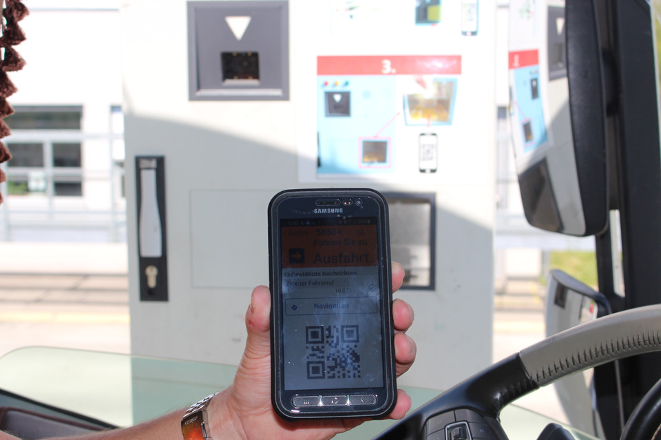 Lkw-Einfahrt mit Smartphone am Werkstor.