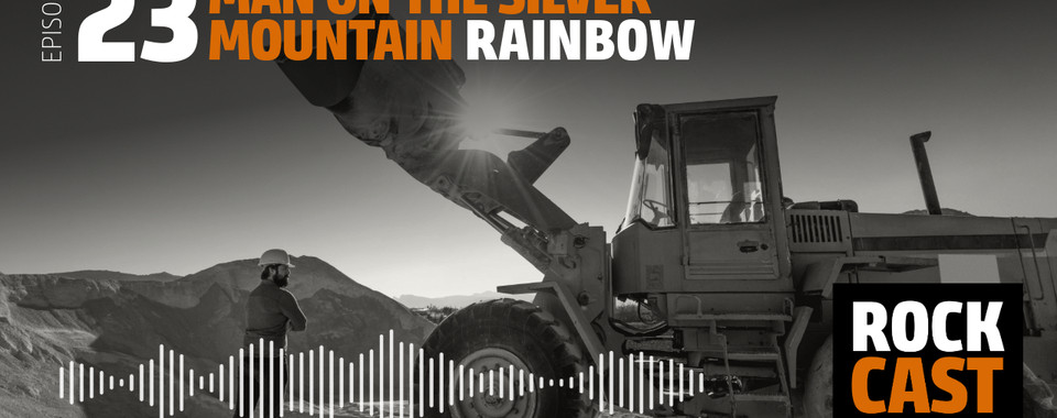 A Man standing next to an excavator. Overlay text reads "Episode 23 Man on the Silver Mountain Rainbow."