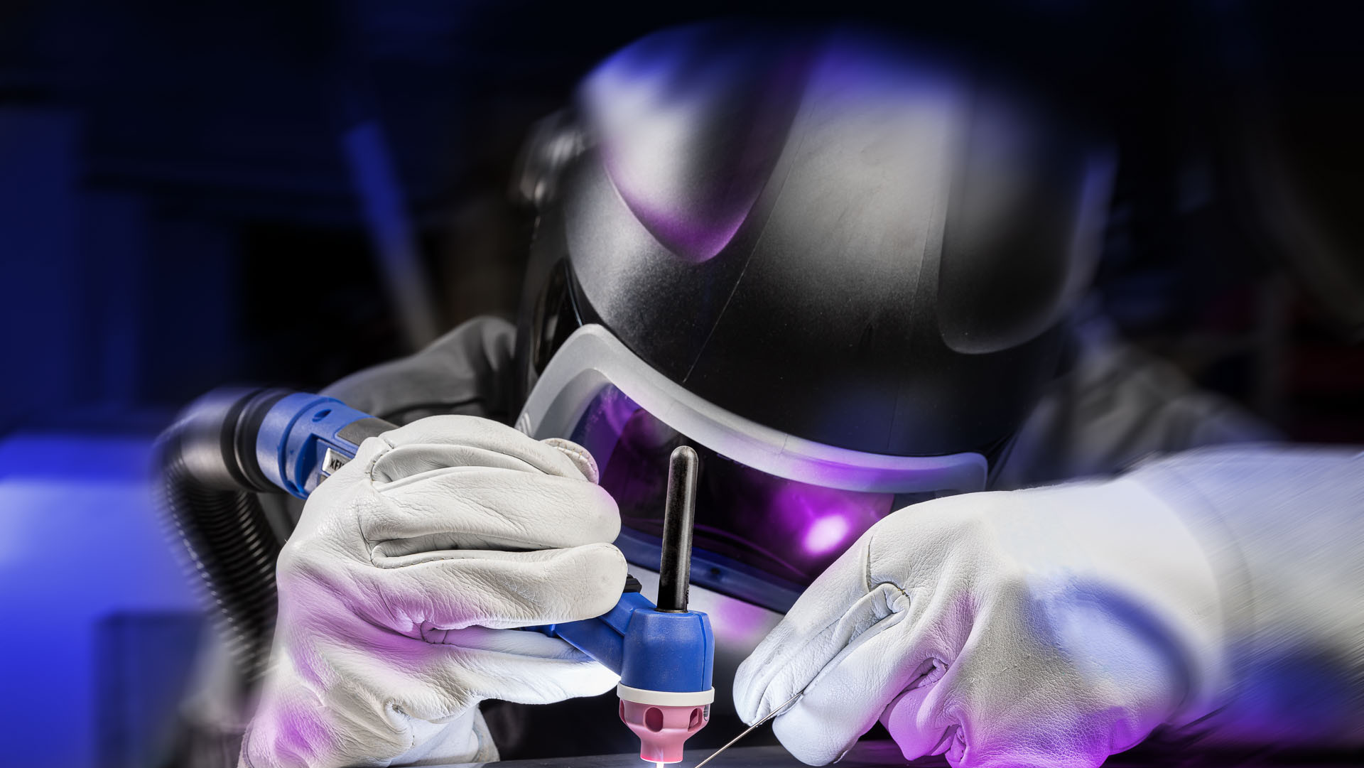 Schweißer mit Schutzausrüstung in Aktion, der Metall mit präziser Technik bearbeitet.