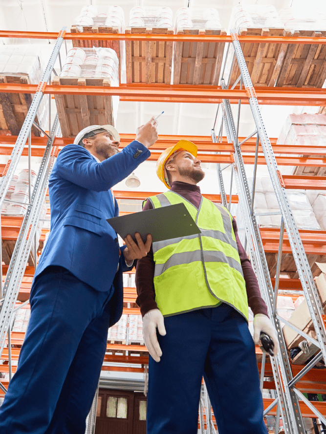 Zwei Disponenten stehen in einem Lager und hält ein Tablet mit Software zur Bestandsoptimierung.