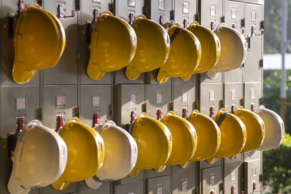 Reihen von gelben Bauhelm an einem Schrank in einer Baustelle, Sicherheitsschutz für Arbeiter und Bauumgebung.