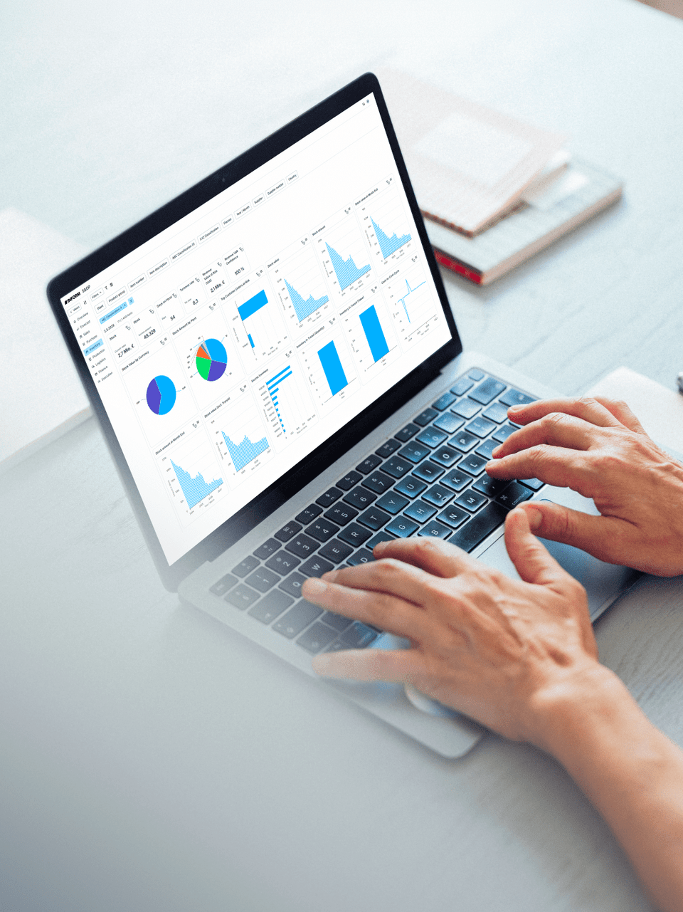 Person analyzing KPIs on a laptop, featuring colorful charts and graphs on a modern workspace table.