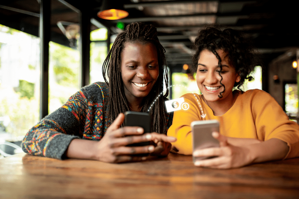 One woman transferns mobile money to woman next to her