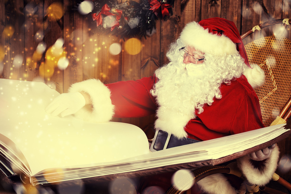 Der Weihnachtsmann liest in einem großen Buch, umgeben von festlicher Dekoration und sanften Lichtern.