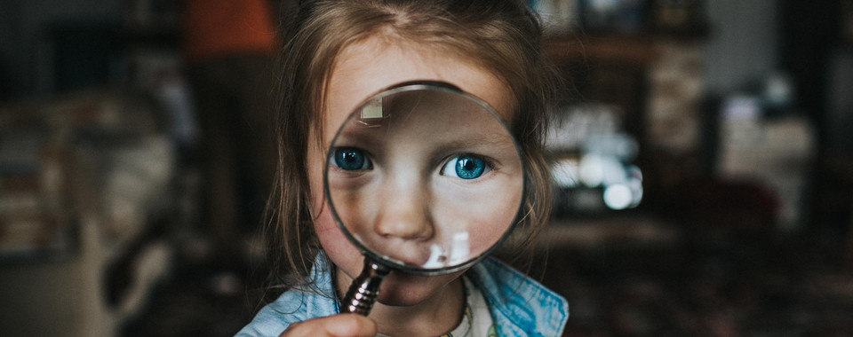 Image of child with magnifyer representing customer screening in KYC and CDD.