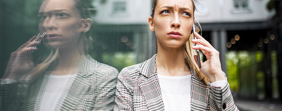 Worried businesswoman on phone – visual metaphor for RiskShield AML for Insurance.