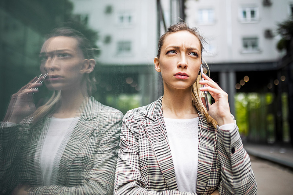 Worried businesswoman on phone – visual metaphor for RiskShield AML for Insurance.